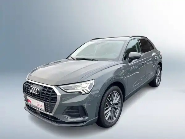 Das Bild zeigt einen grauen Audi Q3 aus der Frontansicht. Es enthält das Händlerlogo von Audi Zentrum Siegen sowie Werbetexte zu Gebrauchtwagen.