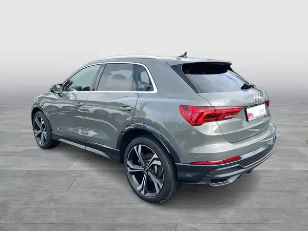 Seitenansicht eines grauen Audi Q3, aufgenommen von der Rückseite.
