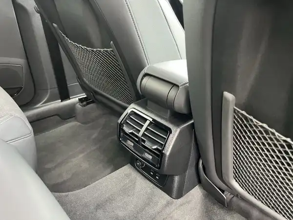 Das Bild zeigt den Innenraum eines Fahrzeugs, speziell den Bereich der Rücksitzbank mit einer grauen Lederausstattung und Belüftungsöffnungen.