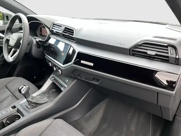 Das Bild zeigt den Innenraum eines AUDI Q3 in schwarz.