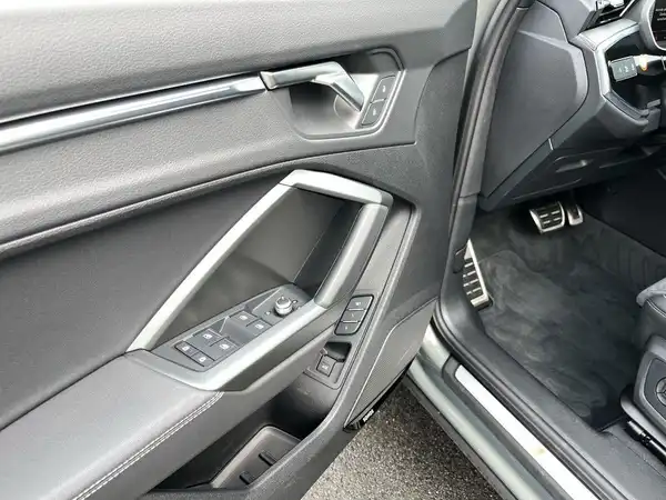 Das Bild zeigt den Innenraum des AUDI Q3, speziell die Fahrertür mit einem schwarzen Interieur.
