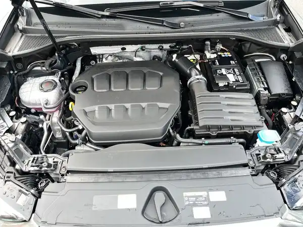 Das Bild zeigt den Motorraum eines AUDI Q3. Es handelt sich um eine Innenaufnahme des Fahrzeugs, die den Motor und andere Komponenten zeigt.