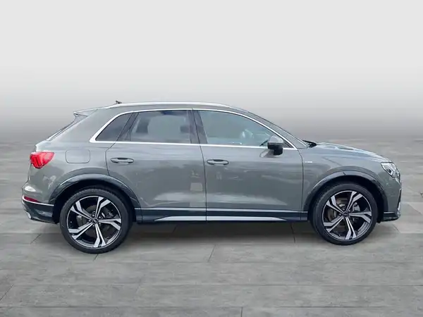 Das Bild zeigt einen grauen AUDI Q3 von der Seite.