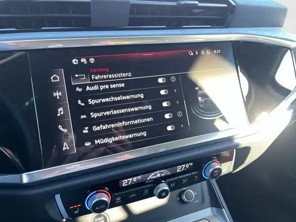 Das Bild zeigt das Innenraumdisplay eines AUDI Q3. Es sind verschiedene Funktionen angezeigt, darunter Fahrerassistenz, Spurwechselwarnung und Informationen zur Fahrzeugdiagnose.