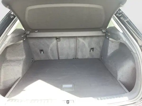 Das Bild zeigt den Kofferraum eines AUDI Q3, aufgenommen von innen, mit grauem Interieur.