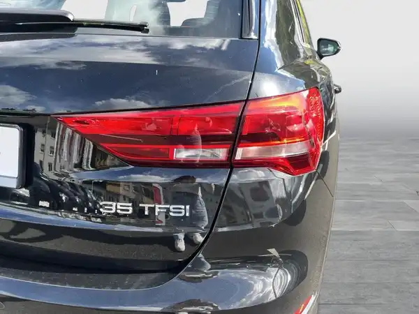 Das Bild zeigt die Rückansicht eines schwarzen AUDI Q3.