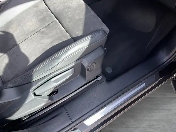 Das Bild zeigt den Innenraum eines AUDI Q3 von der Seite mit einem Sitz und dem Türbereich, die Farben sind schwarz und grau.