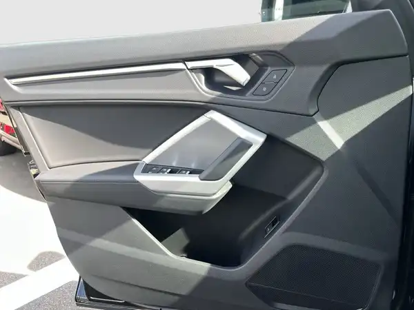 Das Bild zeigt die Innenseite der Fahrertür eines AUDI Q3. Die Türverkleidung ist in Schwarz gehalten.