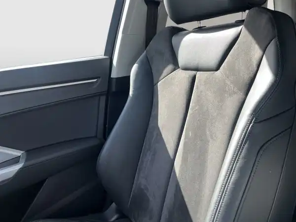 Das Bild zeigt den Innenraum eines Fahrzeugs, genauer gesagt den Fahrersitz, der schwarz ist.