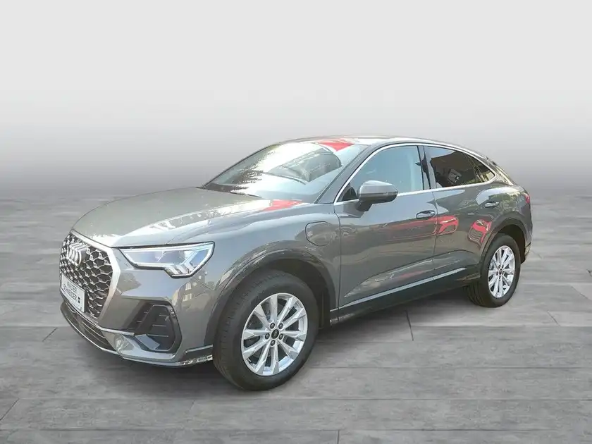 Das Bild zeigt einen grauen AUDI Q3 SPORTBACK, aufgenommen von der Seite.