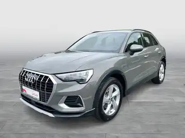 Das Bild zeigt einen grauen Audi Q3 von vorne, mit eingeblendetem Händlerlogo und markanten Texteinblendungen.