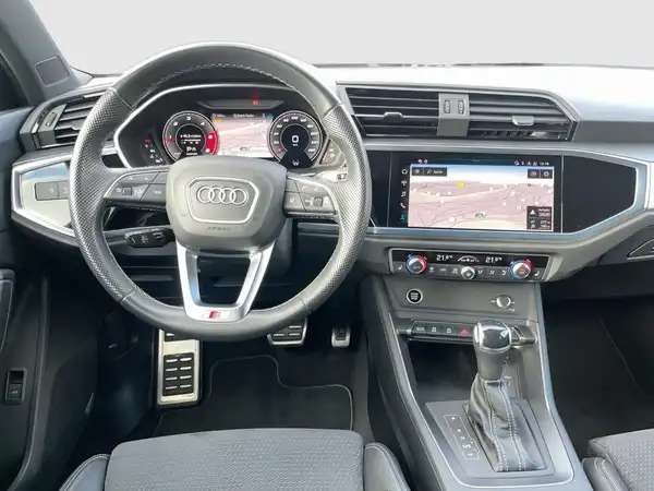 Das Bild zeigt eine Außenansicht des Audi Zentrums Siegen mit Informationen über das Autohaus und den Öffnungszeiten.