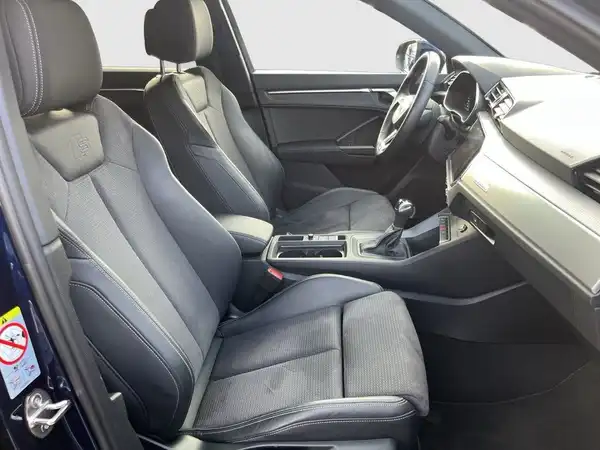 Das Bild zeigt den Innenraum eines AUDI Q3. Die Sitze sind schwarz und erscheinen komfortabel.