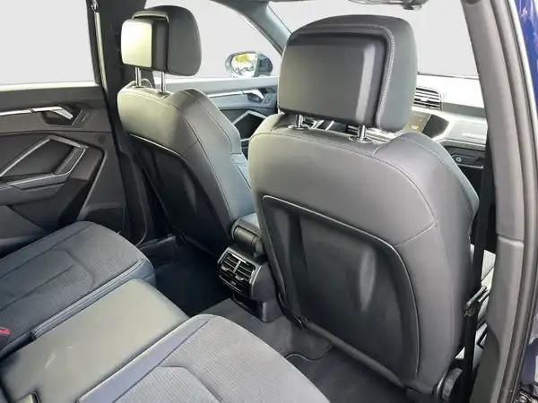 Das Bild zeigt den Innenraum eines AUDI Q3 mit schwarzen Ledersitzen und einer modernen Ausstattung.