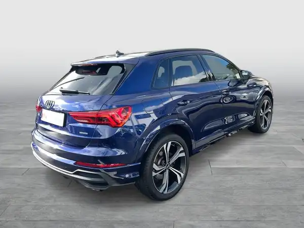 Das Bild zeigt einen blauen AUDI Q3 von hinten, aufgenommen aus einem schrägen Winkel.