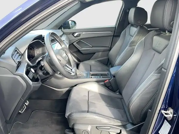 Das Bild zeigt die Innenansicht eines AUDI Q3 mit schwarzen Ledersitzen und einem modernen Cockpit.