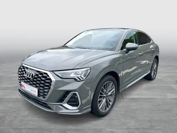 Das Bild zeigt einen grau lackierten Audi Q3 Sportback von der Seite. Es enthält das Händlerlogo und zusätzliche Texteinblendungen.