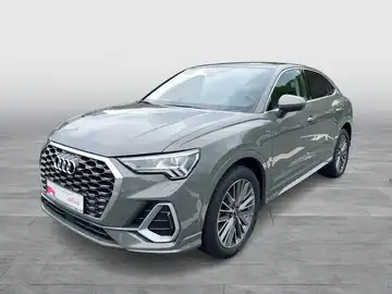 Das Bild zeigt einen grau lackierten Audi Q3 Sportback von der Seite. Es enthält das Händlerlogo und zusätzliche Texteinblendungen.