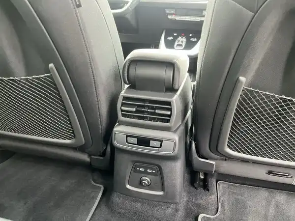 Das Bild zeigt den Innenraum eines AUDI Q4 E-TRON mit einem schwarzen Interieur, insbesondere den Bereich zwischen den Rücksitzen.