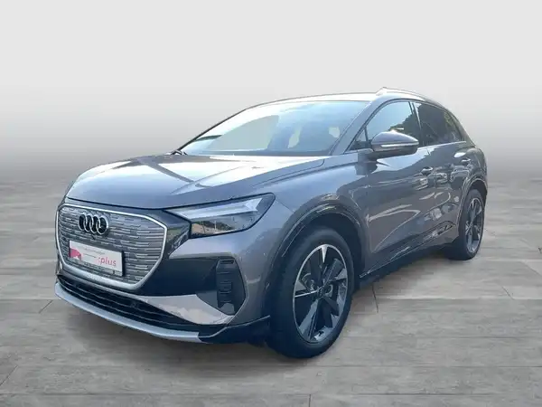 Das Bild zeigt einen grauen Audi Q4 E-Tron von der Seite. Das Händlerlogo ist eingeblendet.