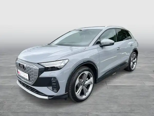 Das Bild zeigt einen Audi Q4 e-tron von der Seite in grauer Farbe.