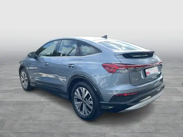 Das Bild zeigt einen Audi Q4 Sportback E-Tron von der Seite in grauer Farbe.