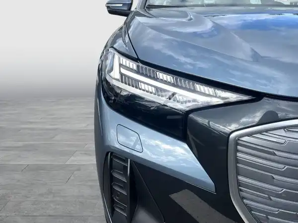Das Bild zeigt die Frontansicht eines schwarzen Audi Q4 Sportback e-tron.