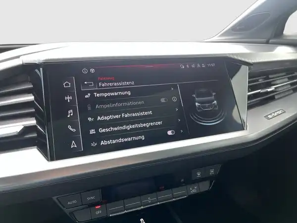 Das Bild zeigt das Innenraum-Display eines AUDI Q4 SPORTBACK E-TRON. Es handelt sich um eine Innenaufnahme des Fahrzeugs, das Interieur ist schwarz. Es sind markante Texteinblendungen zu sehen.