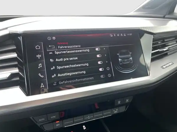 Das Bild zeigt das Innenleben eines Audi Q4 Sportback E-Tron mit einer Benutzeroberfläche, die Fahrassistenzinformationen anzeigt.