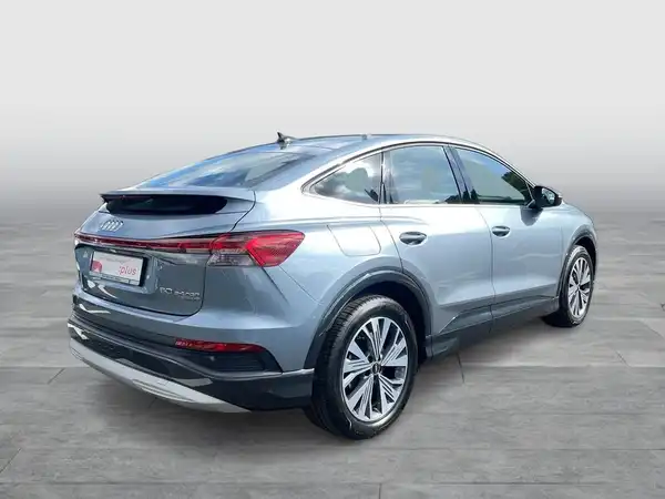 Das Bild zeigt einen Audi Q4 Sportback E-Tron von der Seite in silberner Farbe.