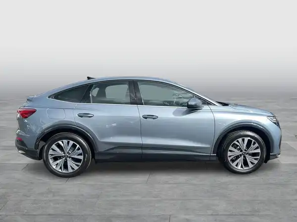 Das Bild zeigt ein seitliches Profil eines blauen AUDI Q4 SPORTBACK E-TRON.