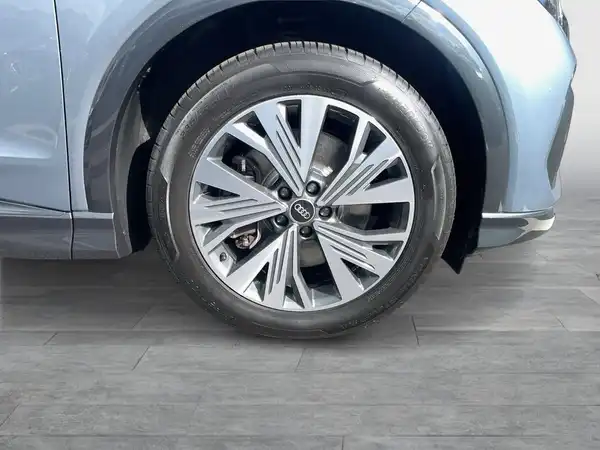 Das Bild zeigt die Seite eines blauen Fahrzeugs, das mit einem Fokus auf das Rad aufgenommen wurde.