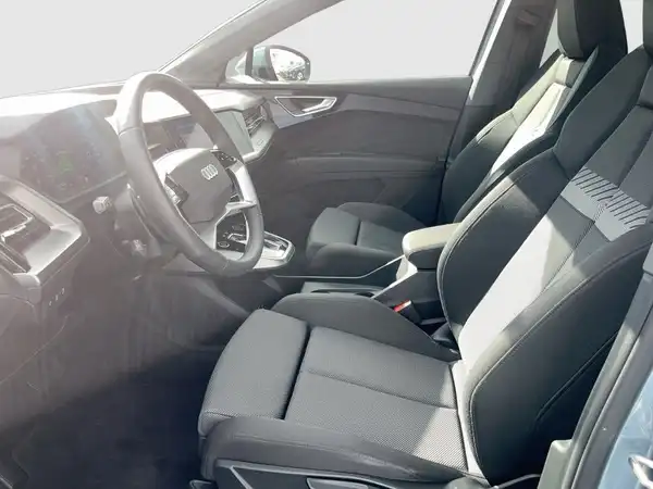 Innenaufnahme des AUDI Q4 SPORTBACK E-TRON mit schwarzen und grauen Sitzen.