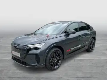 Das Bild zeigt einen schwarzen AUDI Q4 SPORTBACK E-TRON aus der Seitenansicht. Das Fahrzeug hat ein Händlerlogo und enthält markante Texteinblendungen.