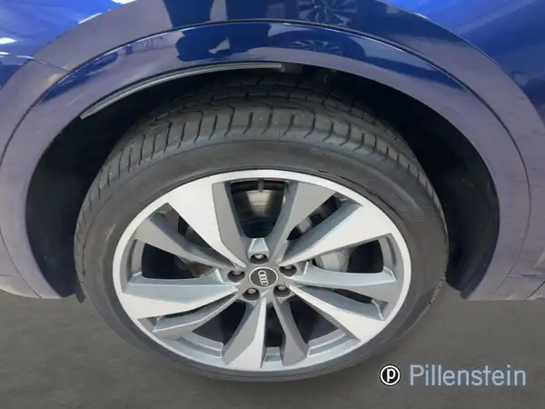 Das Bild zeigt die Felge eines blauen AUDI Q5 von der Seite.