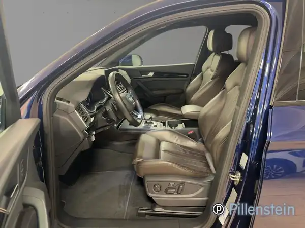Das Bild zeigt das Innere eines blauen AUDI Q5 mit schwarzem Lederinterieur. Händlerschriftzug ist im Bild enthalten.