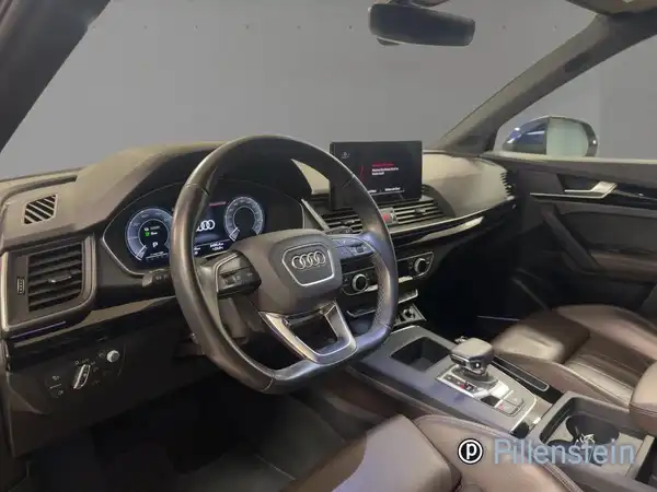 Das Bild zeigt das Innenraum einer Audi Q5 mit einem braunen Interieur. Es enthält ein Händlerlogo in der Ecke.