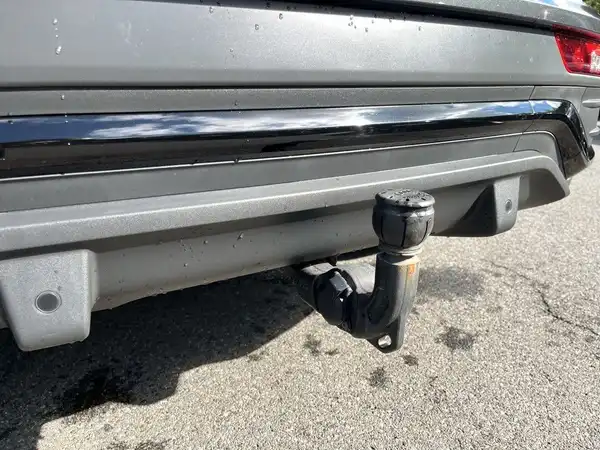 Das Bild zeigt die Rückansicht eines grauen AUDI Q5 mit Anhängerkupplung.