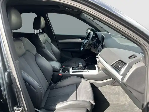 Innenaufnahme des Fahrzeugs, zeigt die Sitze und das Cockpit im Bereich der Fahrerseite.