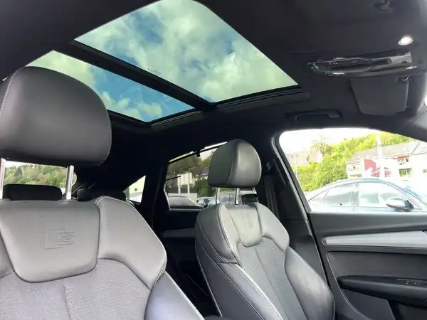 Innenaufnahme des Audi Q5 mit einem dunklen Interieur und einem Panorama-Glasdach.