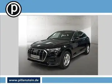 Das Bild zeigt einen schwarzen Audi Q5, aufgenommen von vorne. Das Händlerlogo ist eingeblendet und es gibt markante Texteinblendungen aus der Anzeige.