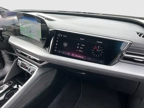 Das Bild zeigt das Innere eines Audi Q5, wobei der Blick auf das Armaturenbrett und das Infotainment-System gerichtet ist. Der Innenraum ist schwarz.