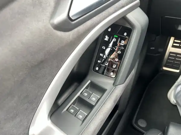 Das Bild zeigt den Innenraum eines Audi Q5, insbesondere die Bedienelemente an der Tür mit einer schwarzen Interieurfarbe.