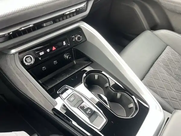 Die Aufnahme zeigt das Innenraum des Fahrzeugs, insbesondere das zentrale Bedienfeld mit einer schwarzen Farbgestaltung.