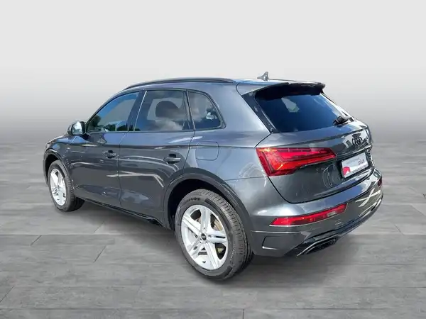Das Bild zeigt einen grauen Audi Q5 aus der Seitenansicht. Es ist ein normales Fahrzeugbild mit einem Händlerlogo.