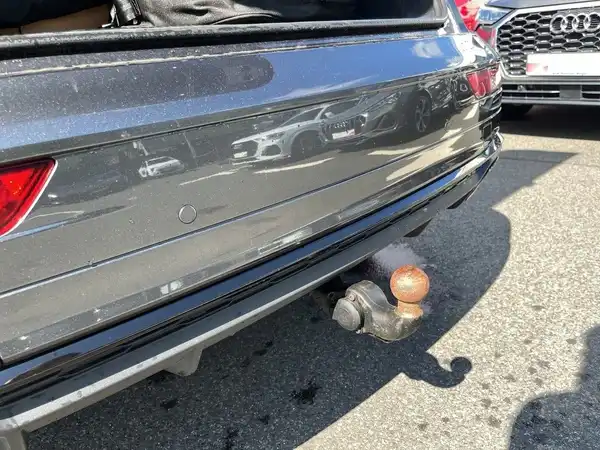 Das Bild zeigt die Rückansicht eines grauen Audi Q5, aufgenommen von hinten.