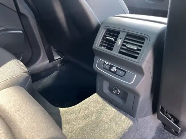 Das Bild zeigt den Innenraum eines AUDI Q5, aufgenommen von der Rücksitzbank mit Sicht auf die Lüftung und Bedienelemente.