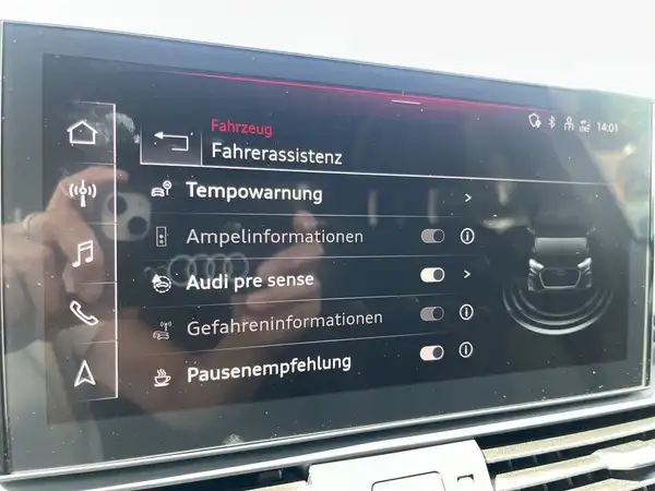 Das Bild zeigt das Innenleben eines AUDI Q5 mit einem modernen Infotainmentsystem. Es sind verschiedene Funktionen für den Fahrerassistenzsystem angegeben.