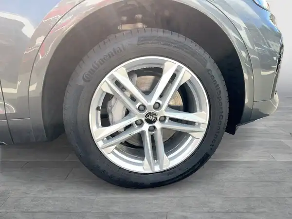 Das Bild zeigt die Seite eines AUDI Q5 mit einem Fokus auf einem Rad und einer Felge in grauer Farbe.