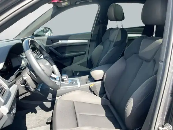 Das Bild zeigt das Innere eines AUDI Q5 mit schwarzen Sitzen und einem modernen Armaturenbrett.
